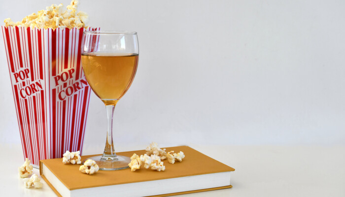 Popcorn and a wine glass on a book